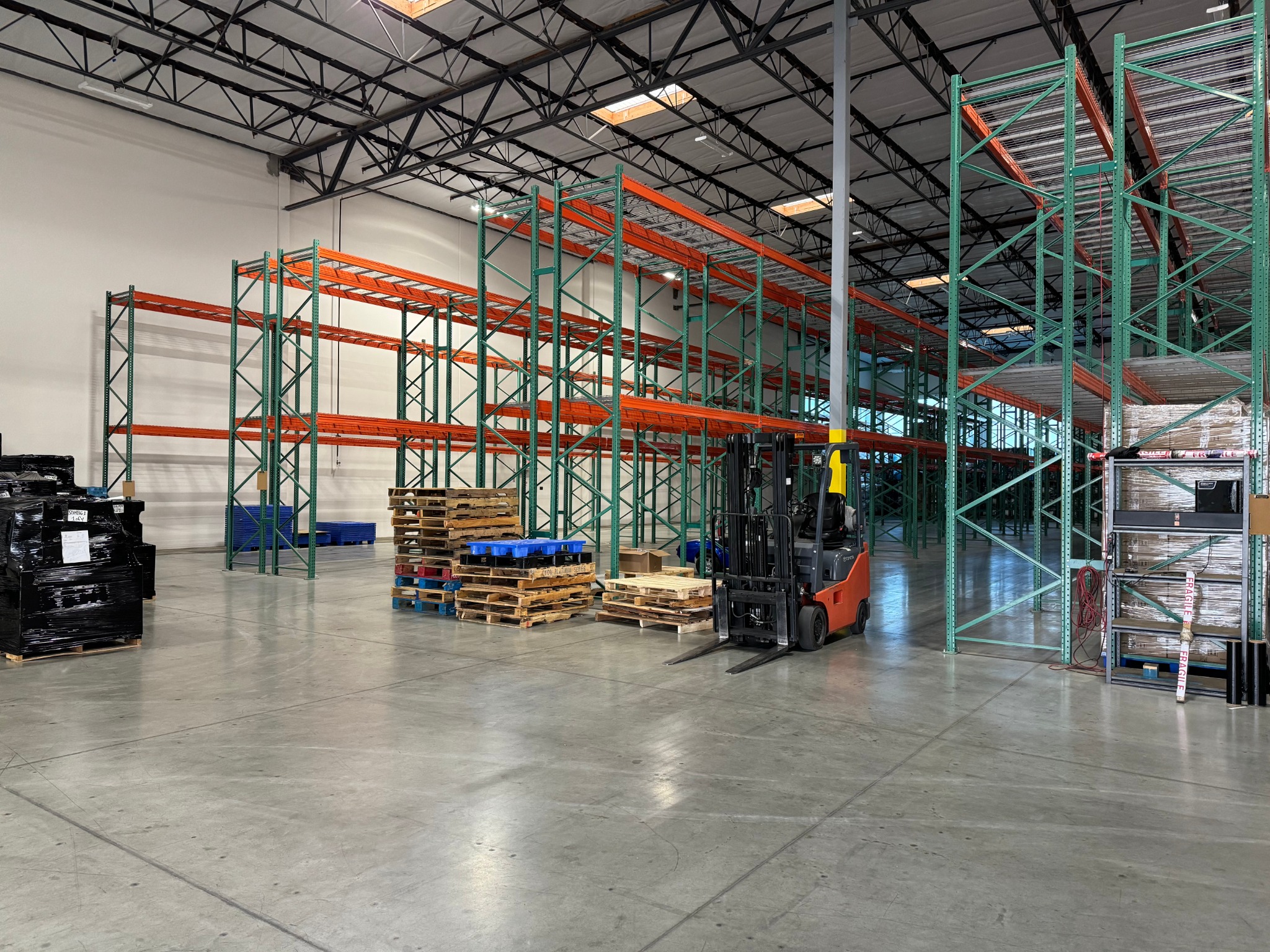 High-bay shelving, pallets, and a forklift inside the VANZILO warehouse in Santa Ana